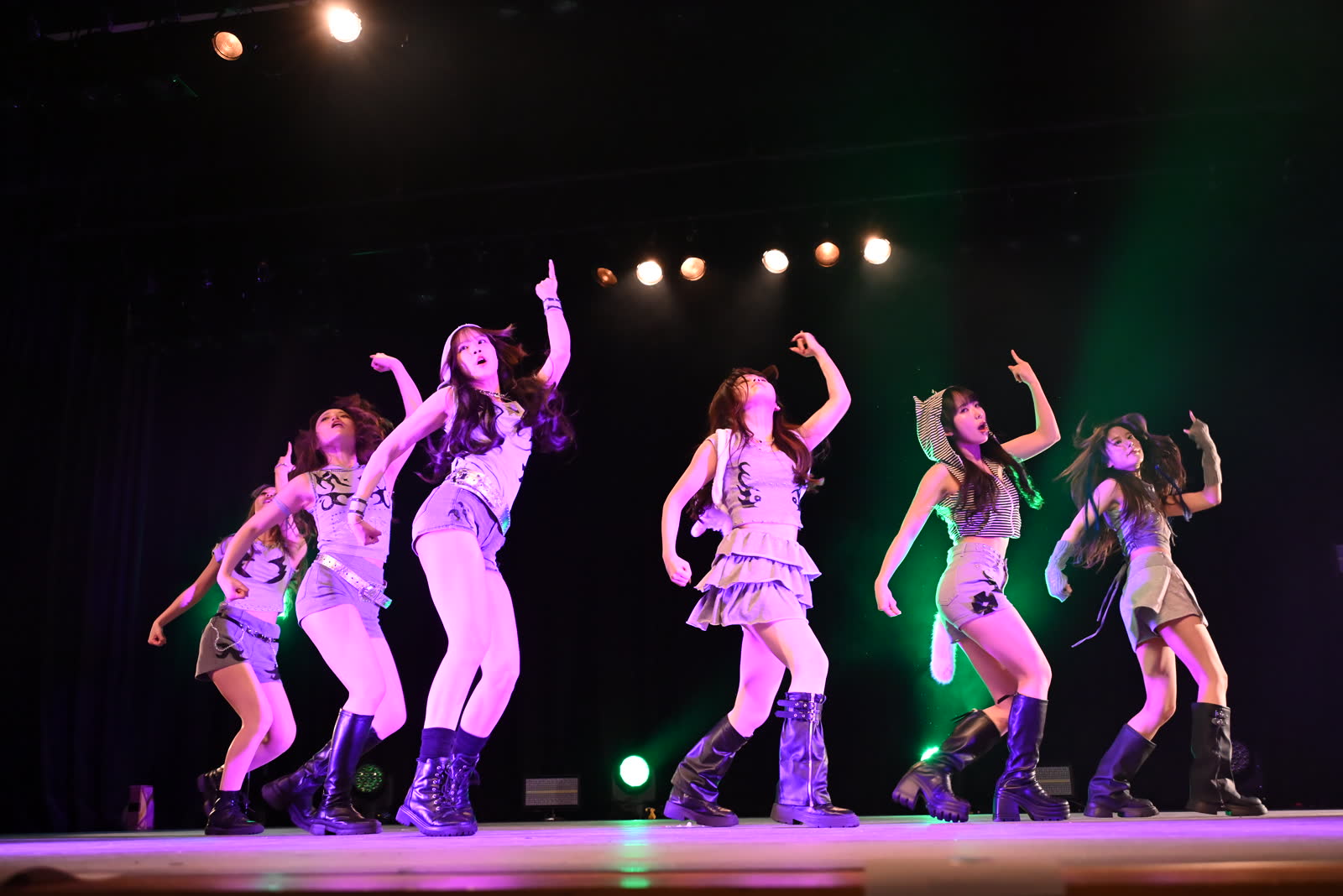 ピンクとグリーンの照明の下でダンスチームが踊る様子